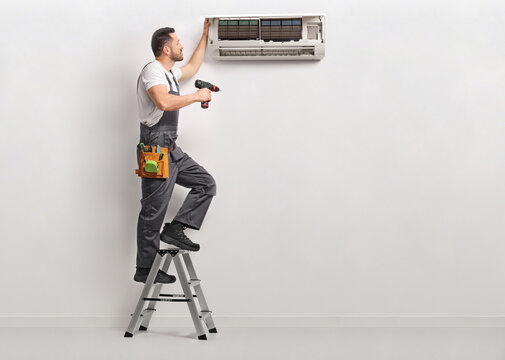 Worker on a ladder repairing AC unit