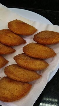 Fried Portuguese rissois, a traditional appetizer, served on a plate lined with paper towel.