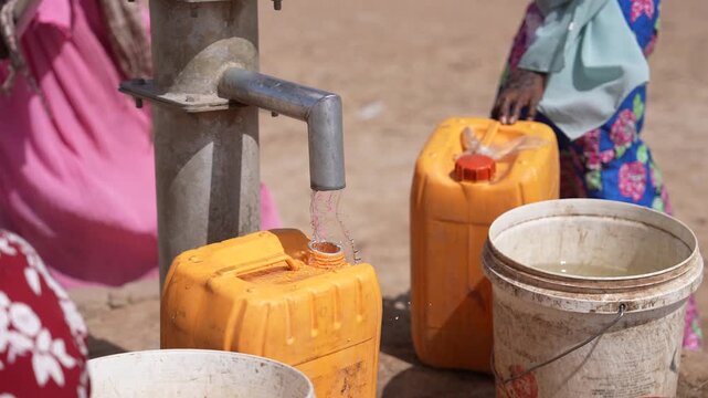 Close up of filling jerrycans with water from village pump, April 25, 2026, Chad, N Djamena
