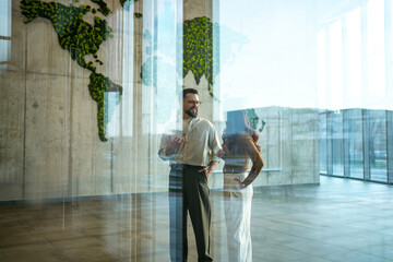 Business partners discussing global strategy in eco-friendly office lobby © Migma_Agency