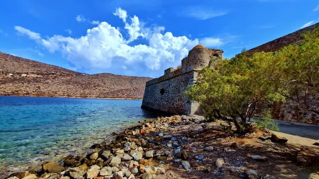Historic fortress on rocky coastline with blue sea and bright sky landscape view