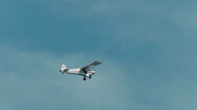 4k long shot of a Cessna plane flying along the Cape Cod coast in slomo