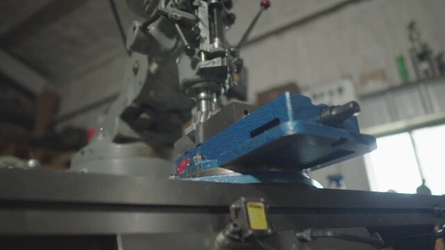 A slow motion close up of a Bridgeport machine grinding metal away and letting it fly towards camera in a cinematic motion
