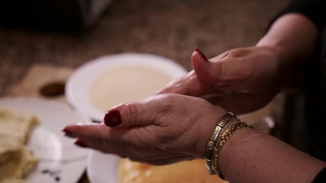 Spanish Croquettes Preparation Dipped in Beaten Egg Before Breading. Closeup of Woman Shaping Homemade Croquetas.