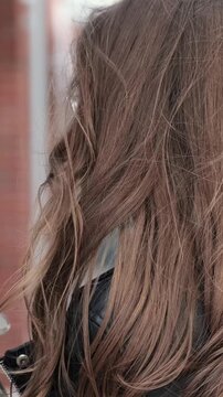 Closeup of a worried girl looking down at her smartphone screen, lips slightly parted as she reads an important notification.
