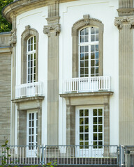 Fototapeta premium Elegant building with large windows and balconies in a public park during daytime