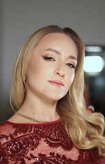 Fototapeta premium Portrait of a woman in her 40s with evening make-up in a fashionable shiny lace dress.