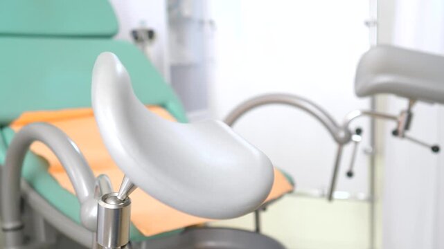 Empty gynecological chair with stirrups in a modern medical office, representing women's health examinations, pregnancy check ups, and specialized healthcare for female patients