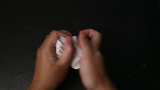 Hand Crumpling a Paper with a Business Plan Diagram on a Black Background