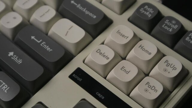 Finger pressing the delete key on a vintage-style mechanical computer keyboard
