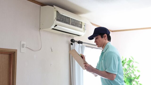 エアコンの状態を確認する清掃スタッフ