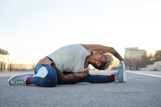 Latina woman stretching outdoors doing yoga exercise