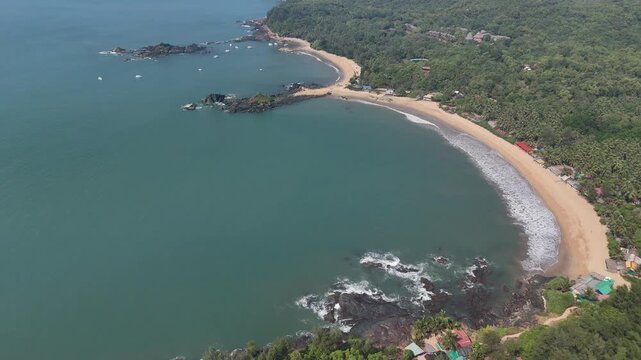 Aerial 4K drone footage of Om Beach in Gokarna India. Stunning bird's eye view of the Om-shaped coastline with turquoise water and rocky cliffs.