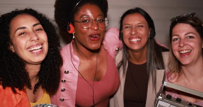 Happy multiracial women having fun dancing together while listening music with cassette, cd player and vintage boombox stereo outdoor - Party, nightlife and people lifestyle concept 
