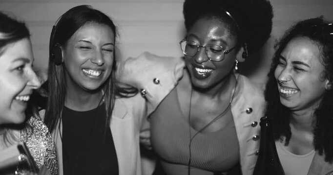 Group of multiracial girls having fun together while listening music with cassette, cd player and vintage boombox stereo outdoor - Party, nightlife and people lifestyle concept - Black and white