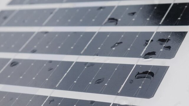 Closeup solar panel surface with water rain droplets showing photovoltaic cell grid pattern renewable clean energy technology