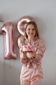 Teenage Girl Holding Birthday Cake During 18th Birthday Celebration