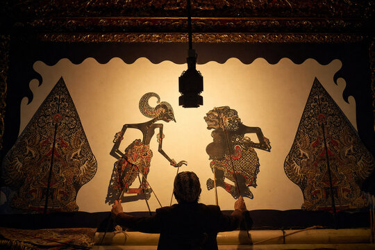 Traditional Javanese wayang kulit shadow puppet performance with puppeteer, Indonesian cultural heritage