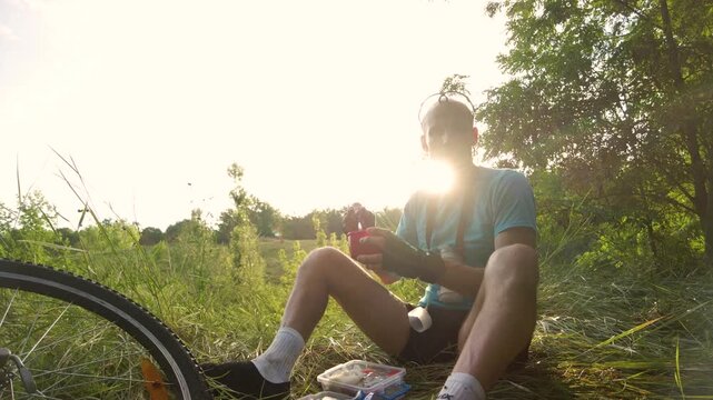 Man cyclist resting and taking pause for snack during ride Bicycle traveler eating snack while resting on roadside during cycling journey in natural environment