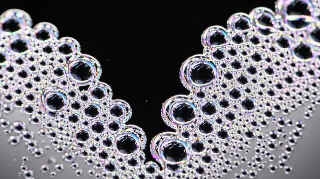 Bubbles forming a heart shape on a black background, showcasing a close-up view of the continuous progression of bubbles merging and expanding in size