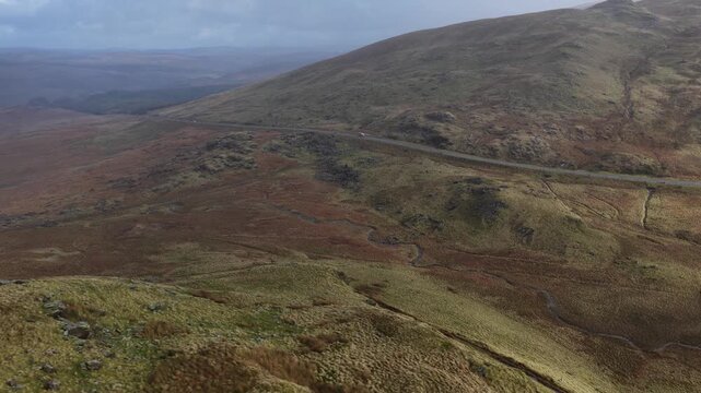 Aerial view of car driving on mountain road in british moorland