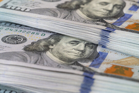 Large stacks of new US hundred dollar bills featuring Benjamin Franklin portrait