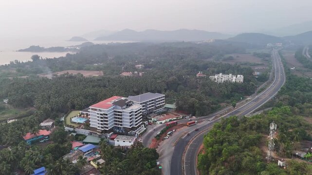 Wide cinematic aerial of a coastal river system featuring elevated bridges, mangrove-covered banks, and curved sandbars stretching through reflective waters under soft haze.