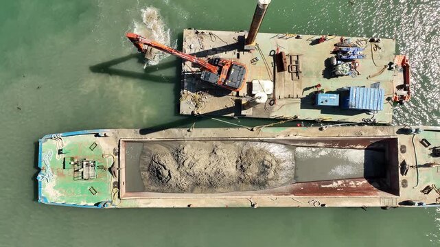 Sand dredging operation at potrrush harbour on northern ireland aerial view of barge and digger working