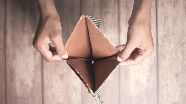 Hands opening an empty wallet.