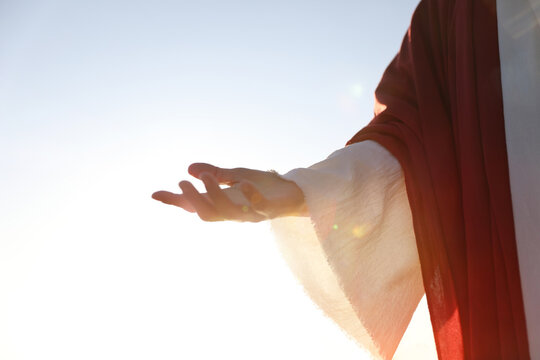 A background of the holy hand of Jesus Christ extending the hand of salvation and guiding souls with the light of love and hope.
