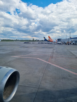 Kyiv, Ukraine - March 15, 2021: Ukraine International Airlines and SkyUp Airlines aircraft parked on apron at Boryspil International Airport under dramatic cloudy sky viewed from passenger airplane wi