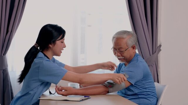 Female nurse provides healthcare home visit medical checkup for senior man, measuring blood pressure with cuff for elderly patient, calm supportive caregiving and wellness near window at home