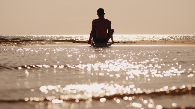 A serene full shot of a man meditating on a tranquil beach at sunrise, with the calm ocean waves gently lapping at the shore, creating a peaceful and spiritual scene.