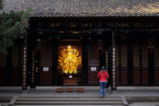 Person approaching golden avalokiteshvara statue, chengdu, china
