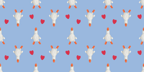 Seamless pattern of geese with hearts on a blue background for fabric design © Olena