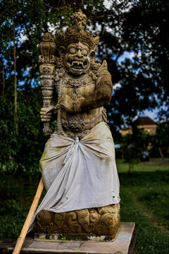 Moss covered Dvarapala guardian statue in Bali, Indonesia