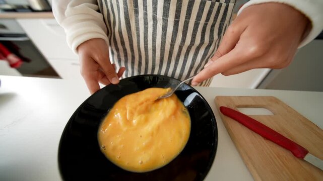 Photographer captures food influencer preparing eggs in black bowl