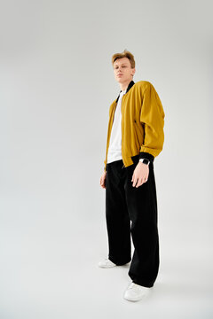 Stylish young man poses confidently in trendy outfit with modern flair