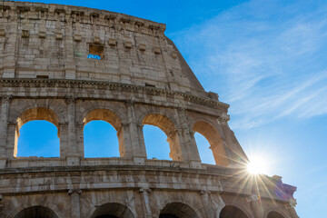 Obraz premium Famous Coliseum in Rome. Colosseum, or Coliseum. Sunset at huge Roman amphitheatre, Rome, Italy, Europe. Famous touristic place in the world and Europe. Beautiful blue sky background.
