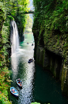 Editorial: Rowing boats on emerald water in Takachiho Gorge with Manai waterfall, Miyazaki, Japan