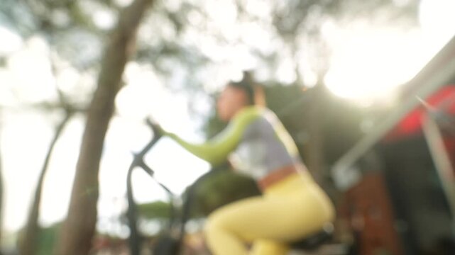 Open park environment shows woman using elliptical machine while recording