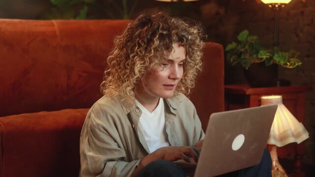 Disappointed curly haired woman reacting to bad results while working on laptop at home. High quality 4k footage