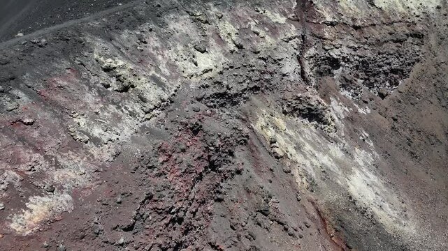 Aerial close-up of the intricate volcanic textures and colorful mineral deposits inside the Pico do Fogo crater, Cabo Verde, showcasing unique geological formations and basaltic rock