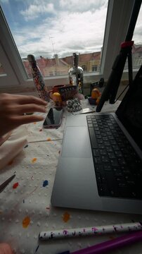 Creative woman manages sewing projects alongside computer tasks in studio