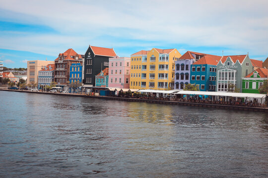 colorful Dutch colonial buildings of Handelskade along St. Anna Bay in the Punda district. Landmarks shown include the yellow Penha building