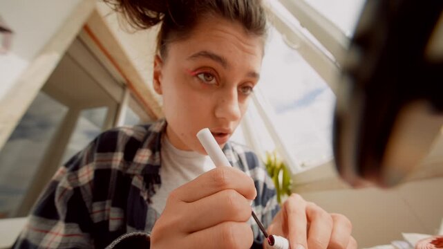 Teen white woman applying pink eyeliner morning makeup vlog