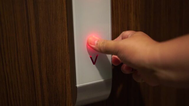 Someone is pressing the elevator button to go up the building.