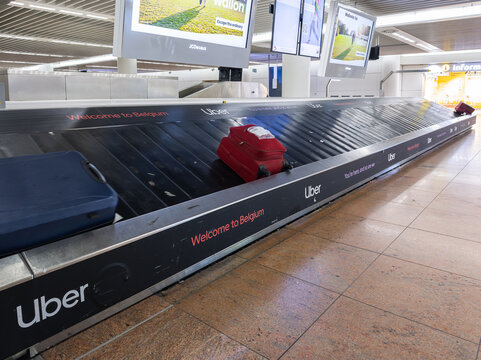 April 17, 2026, Brussels Airport, Zaventem, Belgium. Luggage on baggage claim conveyor belt with airport advertising