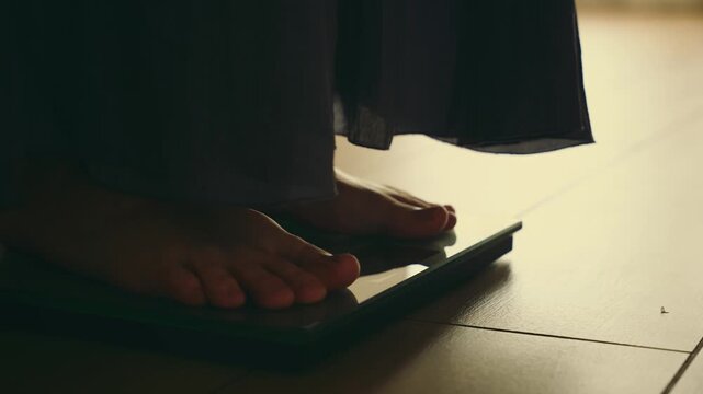 Close up person legs bare feet stepping onto weighing scale at home room. Fitness diet BMI girl slimming healthy lifestyle weight awareness concept. Woman weight lose standing on scales measure weight