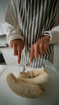Precise cutting of banana segments over mixing bowl by steady hands